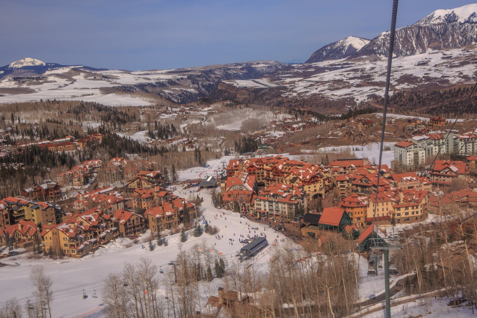 Telluride Mountain Village in winter with snow-covered San Juan peaks behind it