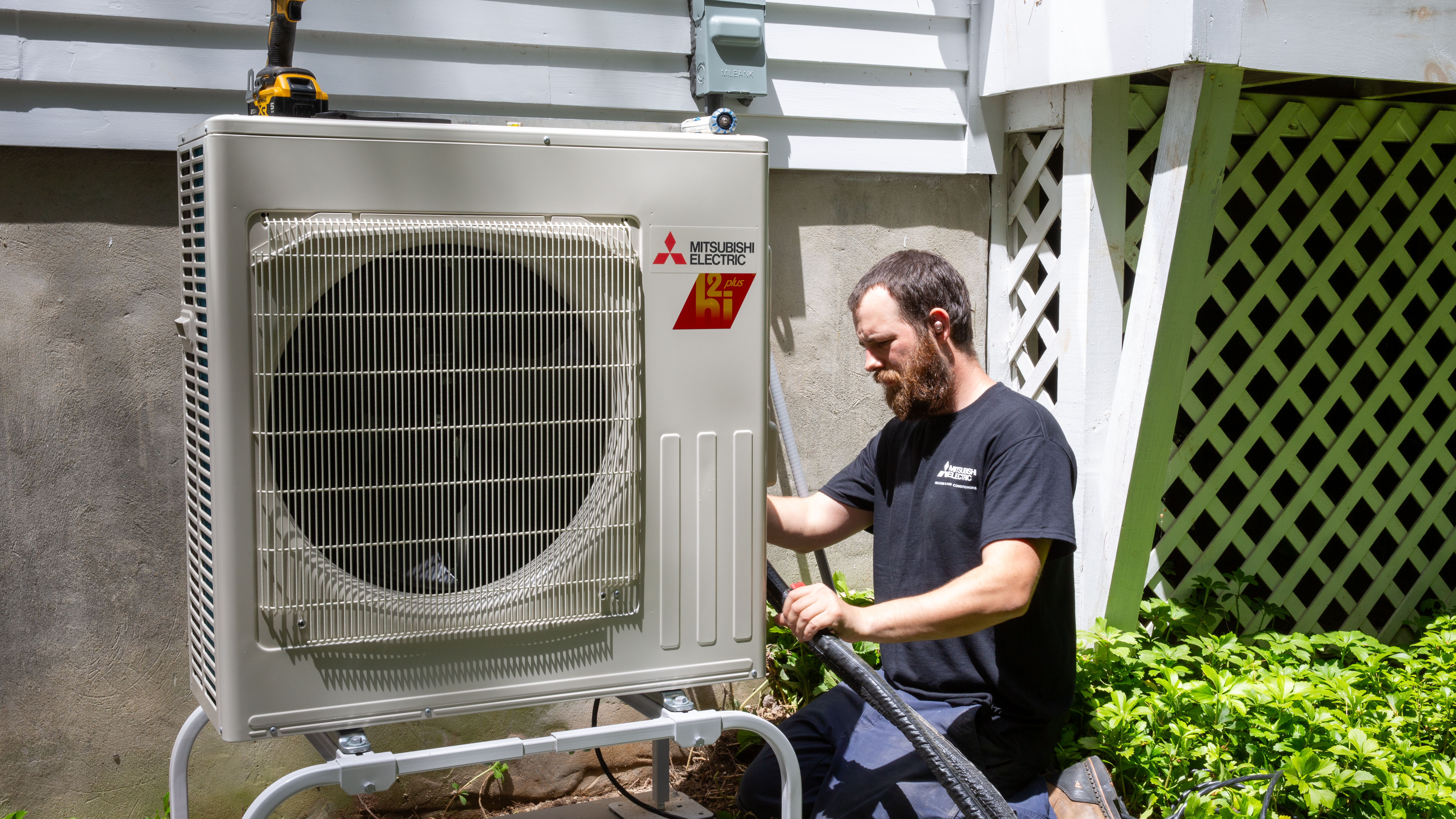 UniColorado technician commissioning a Mitsubishi heat pump outdoor unit